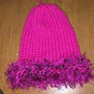 Pink fuzzy winter hat with blue accents